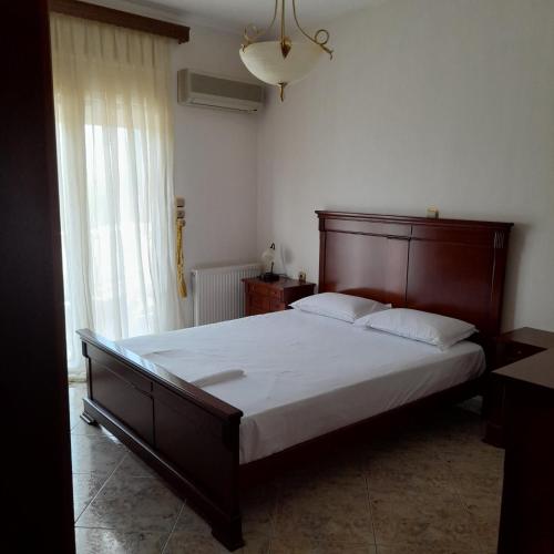 a bedroom with a large bed with a wooden headboard at Villa St.George in Katerini