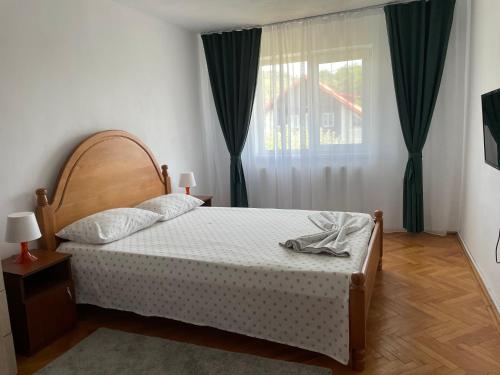 a bedroom with a bed and a window at Cazare Vila Maria in Curtea de Argeş