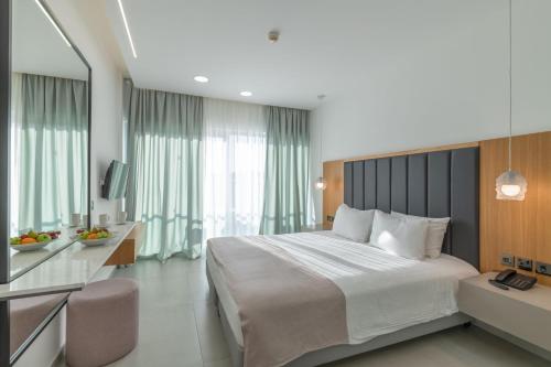 a bedroom with a large bed with a large window at Napa Mermaid Hotel & Suites in Ayia Napa