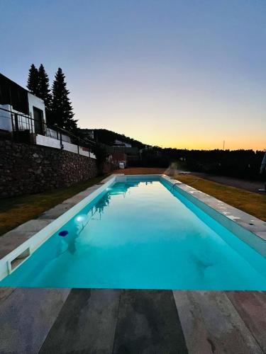 a large blue swimming pool with a person in it at Posada Matadero in Cortelazor