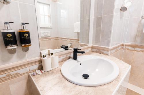 a white bathroom with a sink and a mirror at Villa Lilith Smart in Fertőrákos