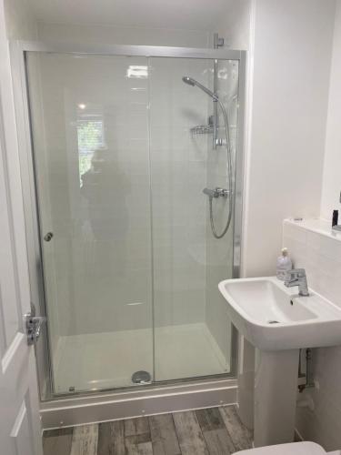 a bathroom with a glass shower and a sink at Peterborough Brand New City Center Apartment 2 Bedroom 2 bath apartment free parking contractors welcome in Peterborough