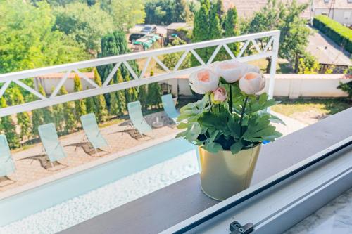 a vase of pink roses sitting on a ledge on a balcony at Villa Lilith Smart in Fertőrákos