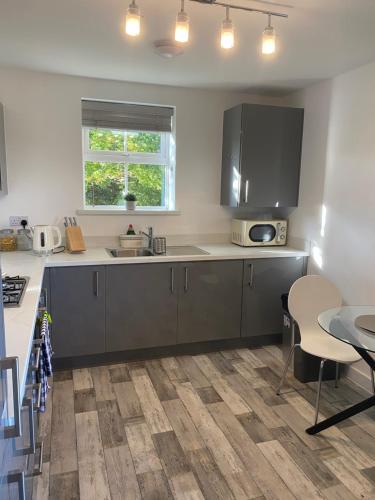 a kitchen with a sink and a counter with a table at Peterborough Brand New City Center Apartment 2 Bedroom 2 bath apartment free parking contractors welcome in Peterborough