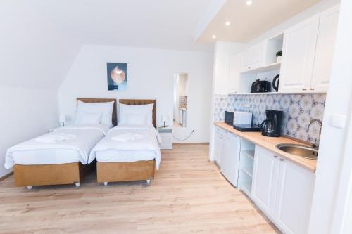 two beds in a small room with a kitchen at Villa Lilith Smart in Fertőrákos
