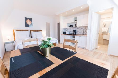a bedroom with a large bed and a kitchen at Villa Lilith Smart in Fertőrákos