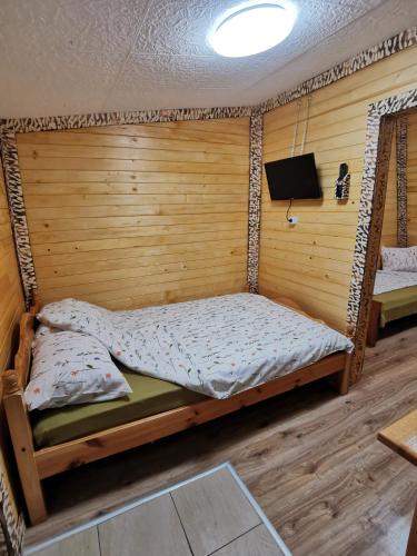 a bedroom with a bed in a wooden wall at Orlino Holiday Park in Sarnitsa