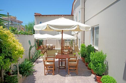 a patio with a table and chairs with an umbrella at Agios Sostis in Kyparissia