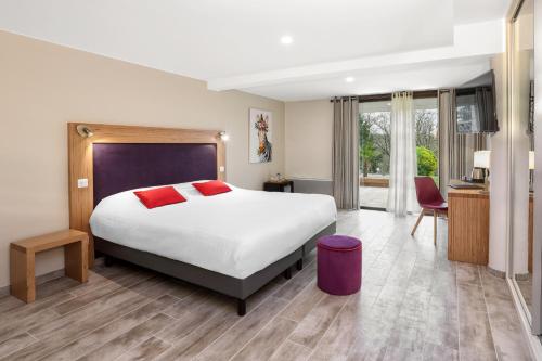 a hotel room with a large bed and a desk at Hotel Restaurant Laborderie in Tamniès
