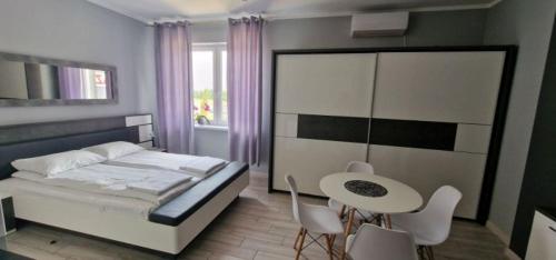 a bedroom with a bed and a table and chairs at Hostel AgMa in Jasień