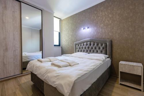 a bedroom with a large bed with towels on it at Panorama Kvariati in Kvariati