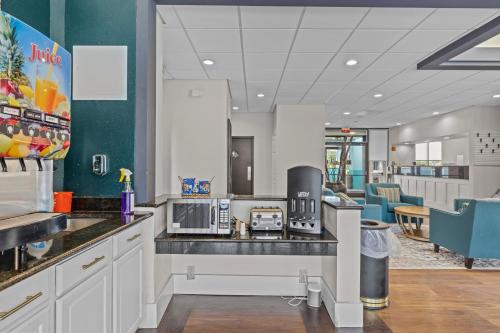 a kitchen with white cabinets and a counter top with a appliance at Garnet Inn & Suites, Morehead City near Atlantic Beach in Morehead City