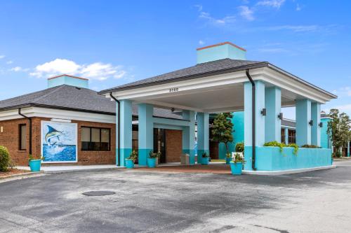 a building with blue columns in a parking lot at Garnet Inn & Suites, Morehead City near Atlantic Beach in Morehead City