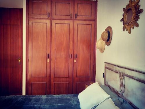 a bedroom with two wooden doors and a bed at Virxen do Carmen 7 alojamiento in Puentecesures