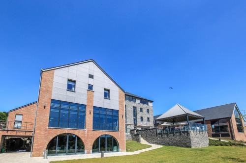 a large brick building with a blue sky in the background at Azur en Ardenne in Durbuy