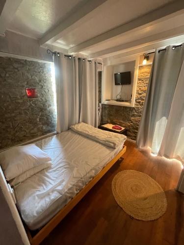 Cette petite chambre comprend un lit avec des draps blancs. dans l'établissement Maison typique Corse, à Oletta