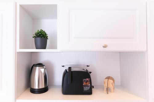 a toaster and a tea pot in a cabinet at Villa Lilith Smart in Fertőrákos