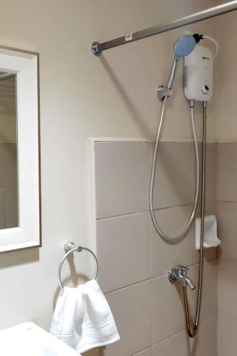 a shower in a bathroom with a towel at Sunvida Tower Stays Across SM City Cebu in Cebu City