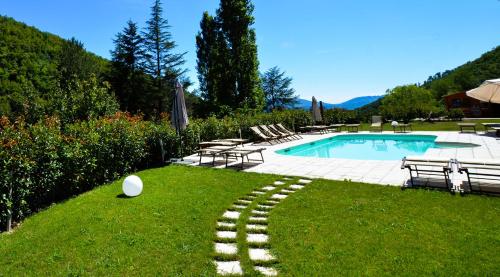a yard with a swimming pool and chairs and a grassy field at Gattaia Apartments with swimming pool in Gattaia