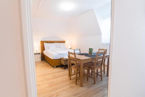 a dining room with a bed and a table and chairs at Villa Lilith Smart in Fertőrákos