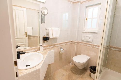 a white bathroom with a sink and a toilet at Villa Lilith Smart in Fertőrákos