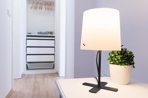 a lamp on a table with a potted plant at Villa Lilith Smart in Fertőrákos