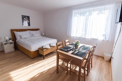 a bedroom with a bed and a table and chairs at Villa Lilith Smart in Fertőrákos