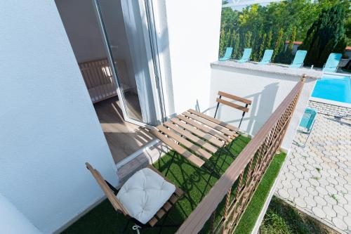 a porch with a wooden bench and a chair at Villa Lilith Smart in Fertőrákos