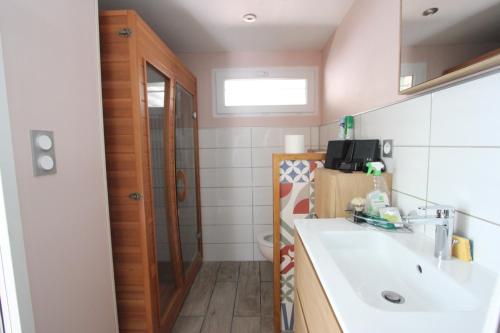 La salle de bains est pourvue d'un lavabo et de toilettes. dans l'établissement Maison au bord de l'eau avec Jacuzzi, à Millau