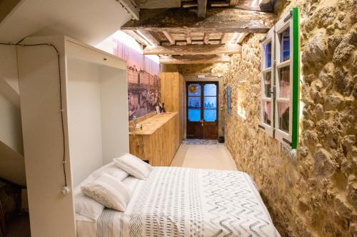 a bedroom with a bed and a stone wall at Apartamento Ciudad Vieja Coruña in A Coruña