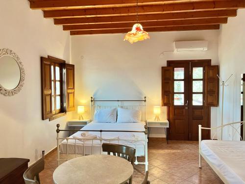 een slaapkamer met een bed en een tafel en stoelen bij Litois Houses Patmos in Sapsila
