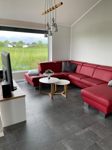 a living room with a red couch and a tv at Ferienhaus G32 in Butjadingen