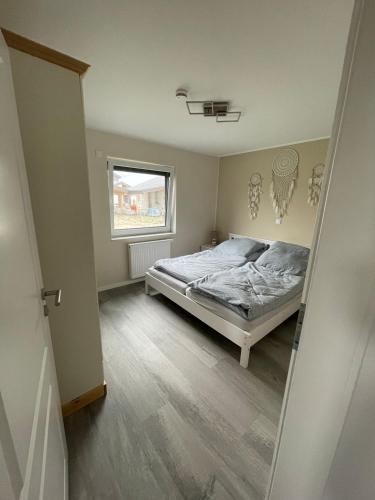 a bedroom with a bed and a window at Ferienhaus G32 in Butjadingen
