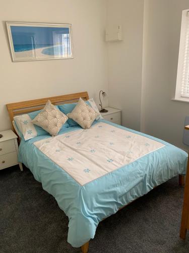 een slaapkamer met een bed met blauwe lakens en kussens bij The old forge 