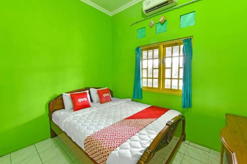 En eller flere senge i et værelse på SPOT ON 91357 Hotel Mulyo