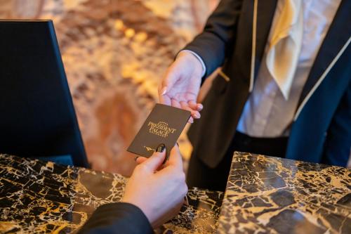 a person in a suit is holding a passport at Prezident Palace Belgrade - Adults Only in Belgrade