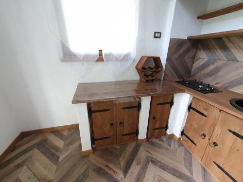 a kitchen with wooden cabinets and a wooden floor at Apartma Kačwa in Kobarid