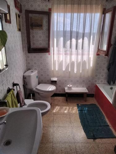 uma casa de banho com um lavatório, um WC e uma janela. em Ca l'Anna i l'Antonino em Maldá