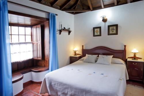 een slaapkamer met een wit bed en een raam bij Casa Rural Tio Pedro in Mazo