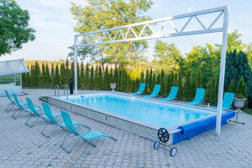 a large swimming pool with chairs and a canopy at Villa Lilith Smart in Fertőrákos