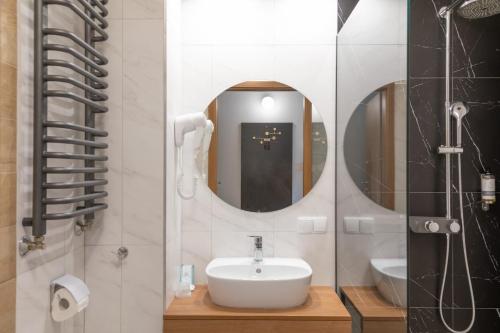 a bathroom with a sink and a mirror at Sudecki Resort & SPA in Karpacz