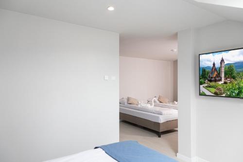 a bedroom with a tv hanging on a wall at Sudecki Resort & SPA in Karpacz