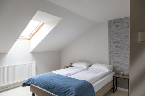 a bed in a white room with a window at Sudecki Resort & SPA in Karpacz
