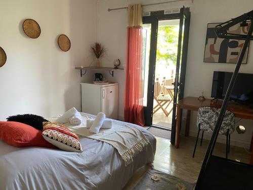 Schlafzimmer mit einem Bett und einer Tür zu einer Terrasse in der Unterkunft Ti kaz bo - Chambre Papaye chez l'habitant in Bras-Panon