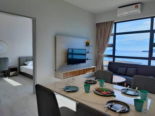 a room with a dining table and a living room at Lovely Seaview Condo TII @ Jesselton Quay in Kota Kinabalu