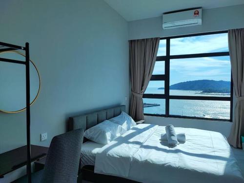a bedroom with a bed and a large window at Lovely Seaview Condo TII @ Jesselton Quay in Kota Kinabalu