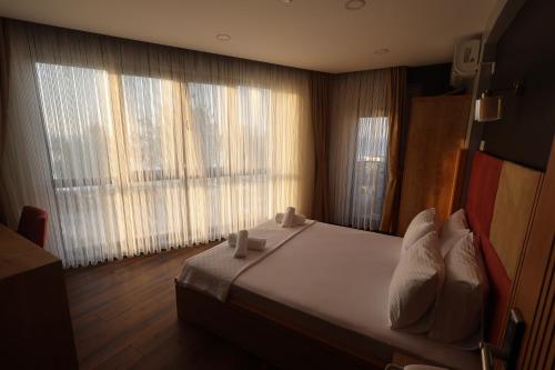 a bedroom with a bed and a large window at Taşliman Otel in Yalova