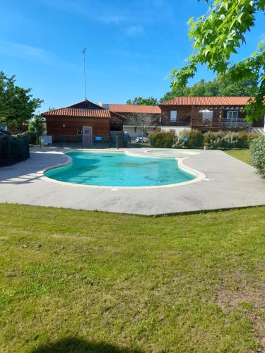une piscine dans une cour avec un bâtiment en arrière-plan dans l'établissement Appartement les Terrasses du Lac, à Aureilhan