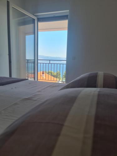 a bedroom with a bed and a view of the ocean at Apartments Jelica in Slatine