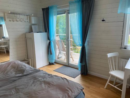 a bedroom with a bed and a sliding glass door at Stuga in Myggenäs